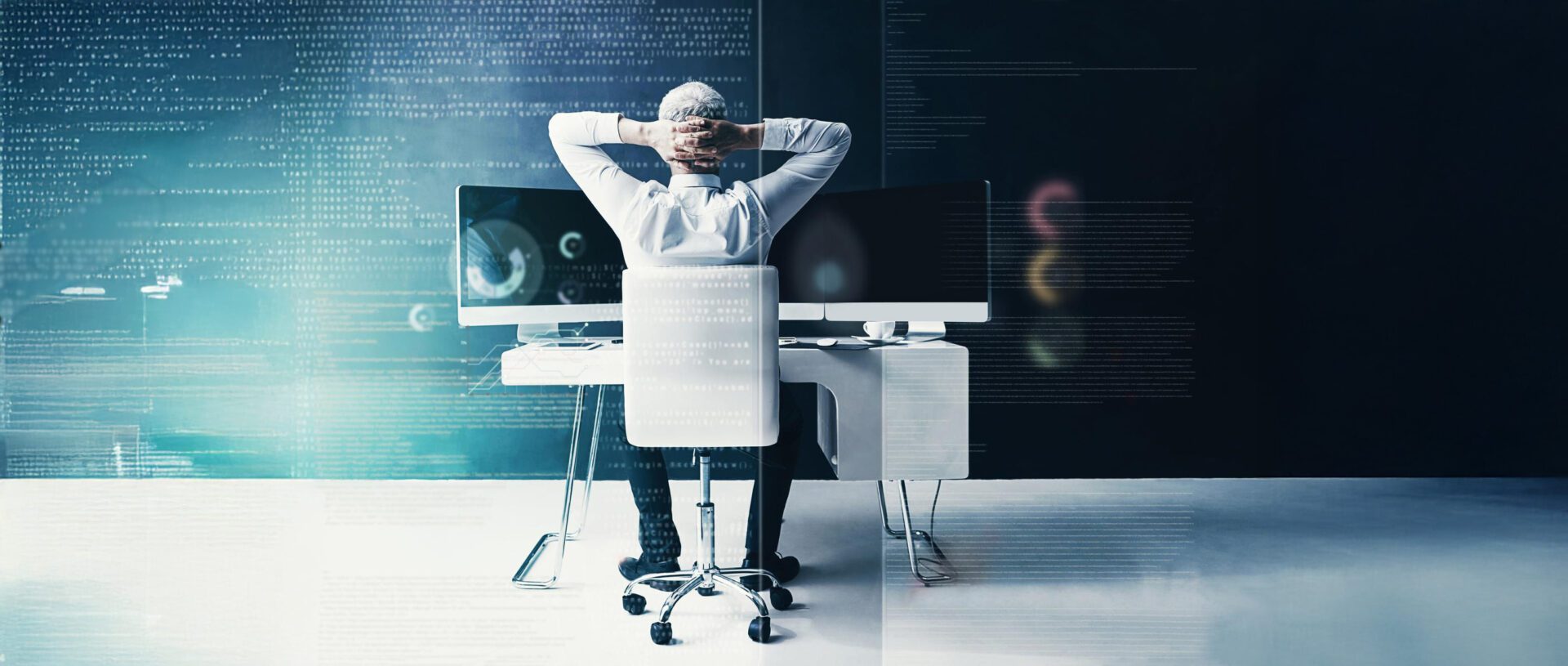 man at desk of computer monitors