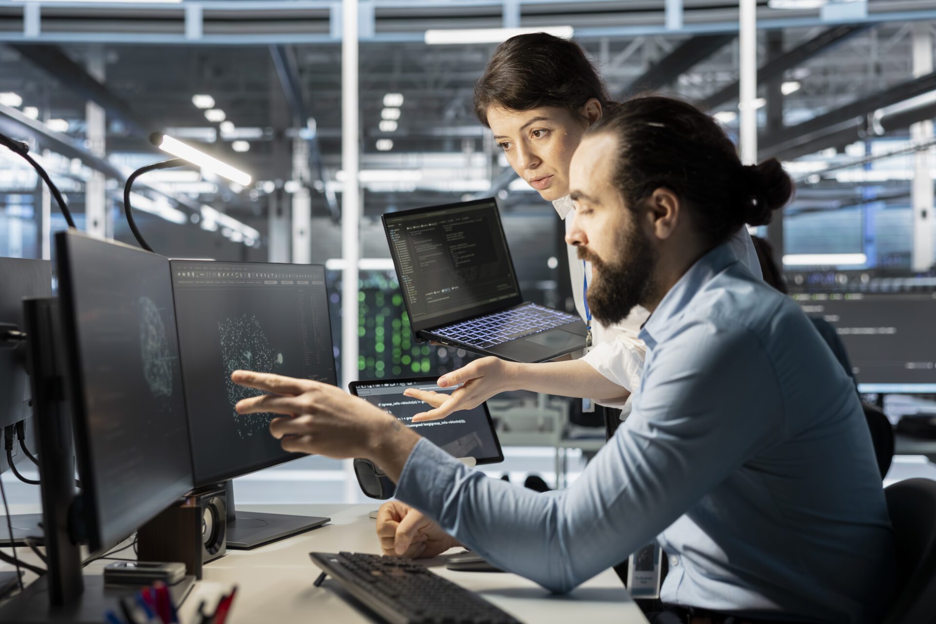 manager guiding strategic partner technician using a monitoring system on a PC. Leader overseeing worker troubleshooting glitches